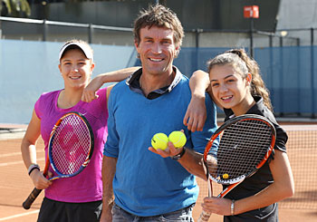 Pat Cash poses with 2012 Gallipoli Youth Cup winner Ellen Perez (L) and Sera Yavuzcan (R) at the clay courts at Melbourne Park's National Tennis Centre